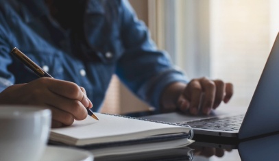Master's in public policy student taking notes at laptop